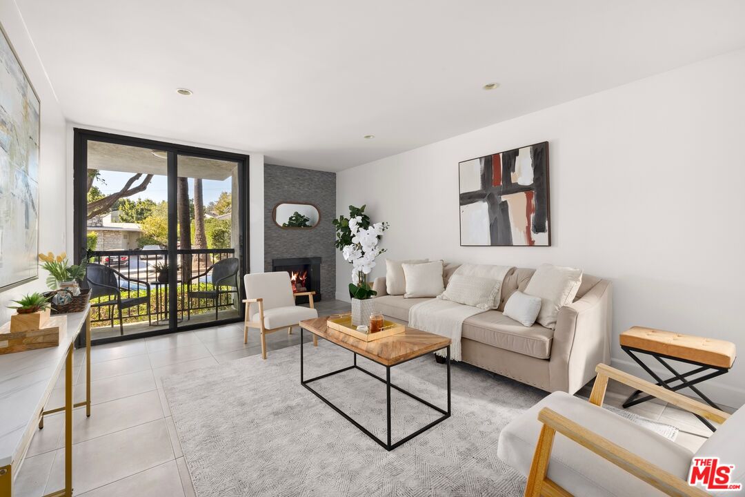 a living room with furniture and a floor to ceiling window