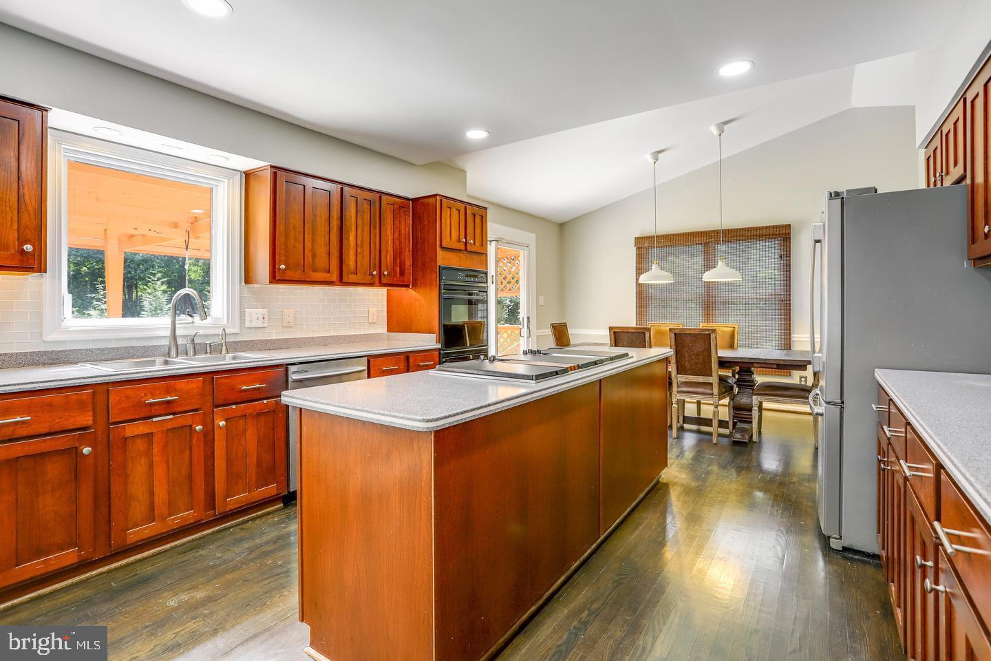 931 Welham Green Road Great Falls, VA 22066 - Photo 13 of 75 a kitchen with stainless steel appliances granite countertop sink stove top oven and cabinets