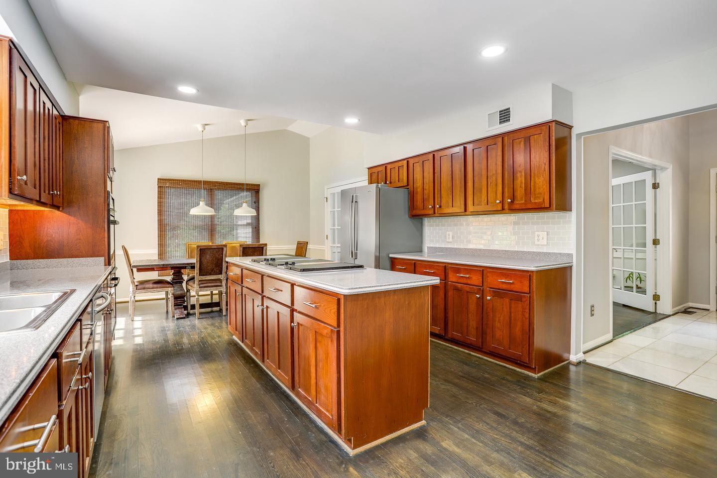 931 Welham Green Road Great Falls, VA 22066 - Photo 14 of 75 a kitchen with stainless steel appliances granite countertop wooden floors and sink