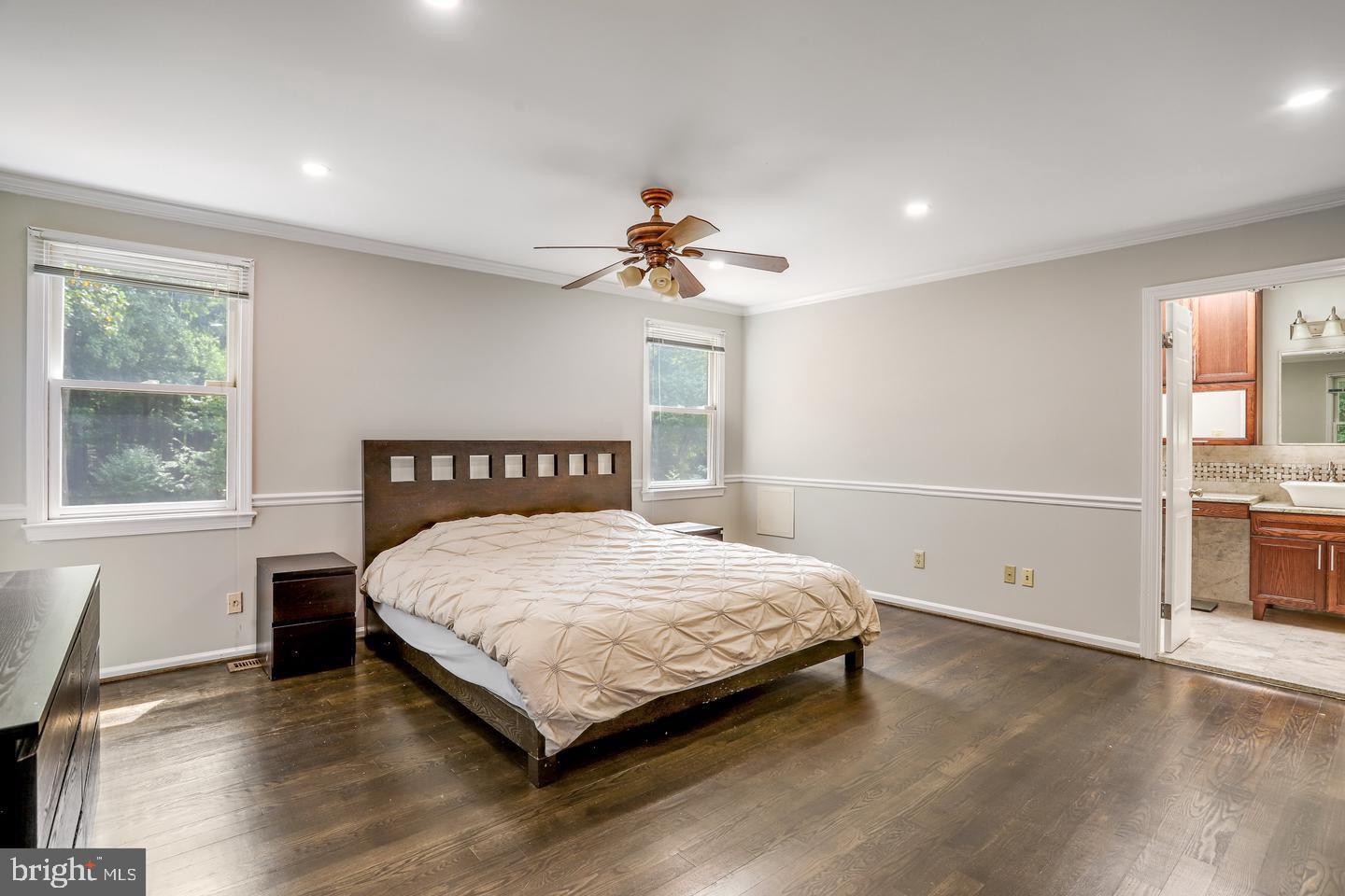 931 Welham Green Road Great Falls, VA 22066 - Photo 35 of 75 a bedroom with a large bed and a chandelier