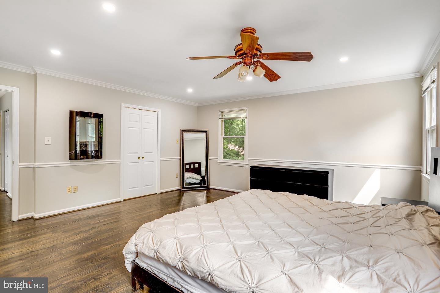 931 Welham Green Road Great Falls, VA 22066 - Photo 36 of 75 a bedroom with a large bed and a chandelier