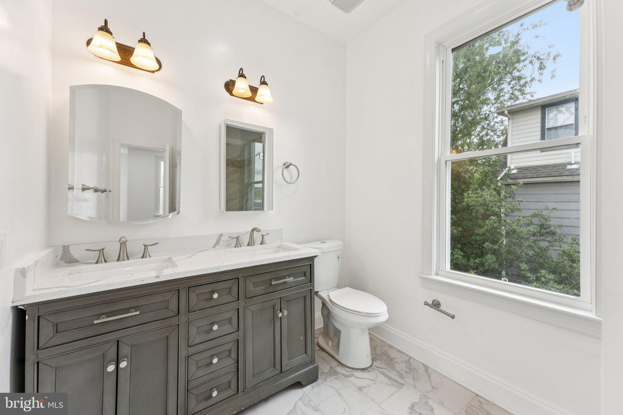 2105 4th Street Northeast Washington, DC 20002 - Photo 18 of 30 a bathroom with a granite countertop toilet sink and mirror