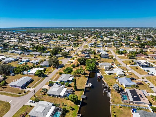 an aerial view of a city with lots of residential buildings and parking space