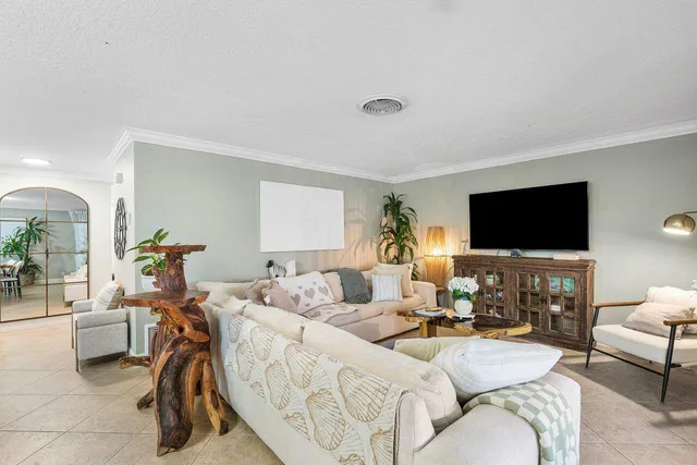 a living room with furniture a flat screen tv and a window