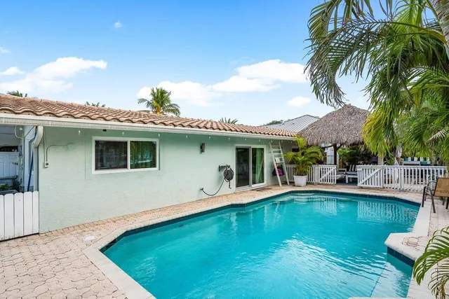 a view of a house with swimming pool and sitting area