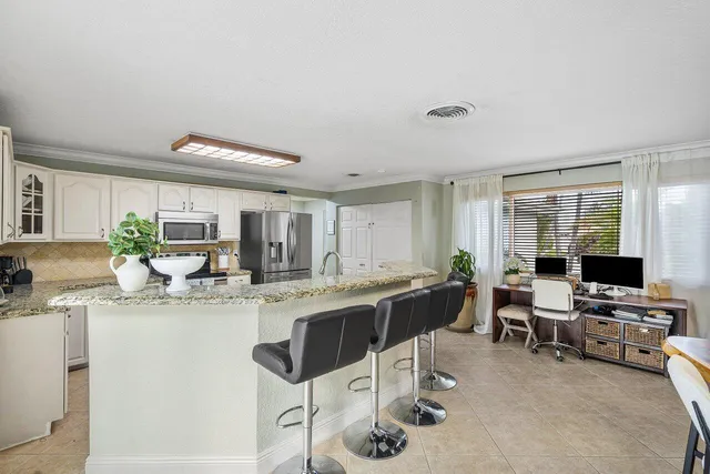 a kitchen with stainless steel appliances kitchen island granite countertop a sink and cabinets