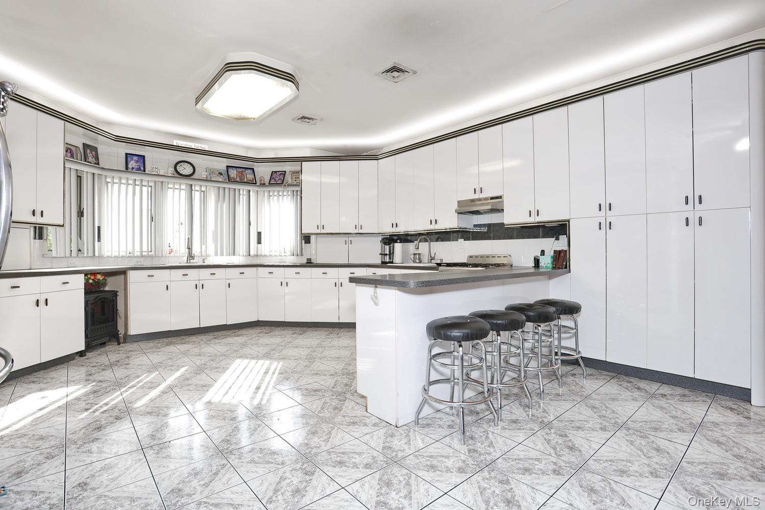 1 Morris Road Spring Valley, NY 10977 - Photo 5 of 50 Kitchen featuring an expansive layout, white cabinetry, dark countertops, an eat-at island, and tile flooring
