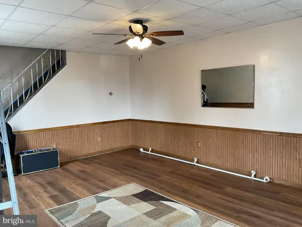 a view of an empty room with a chandelier fan