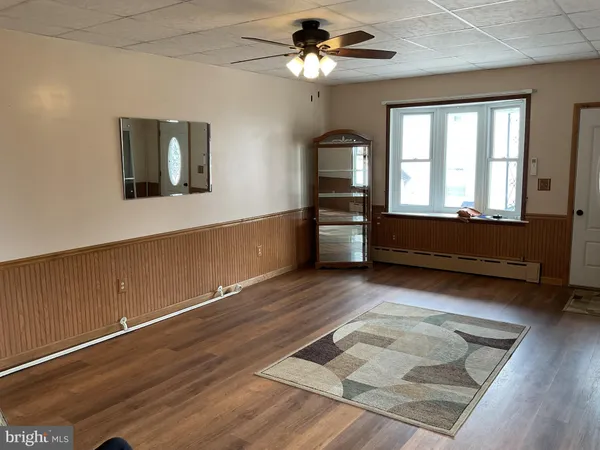 a living room with hardwood floor furniture and a ceiling fan