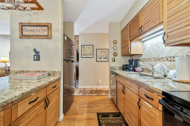 a large kitchen with stainless steel appliances granite countertop a stove a sink and a refrigerator