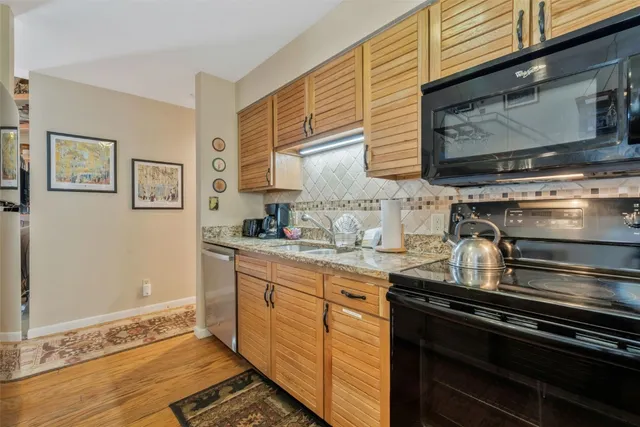 a kitchen with granite countertop stainless steel appliances and wooden cabinets