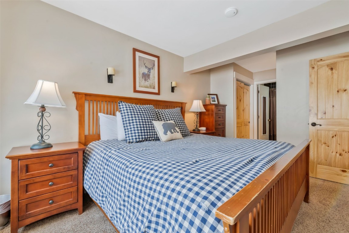 2025 Walton Creek Road, Unit 401 Steamboat Springs, CO 80487 - Photo 16 of 38 a bedroom with a bed and a lamp on dresser