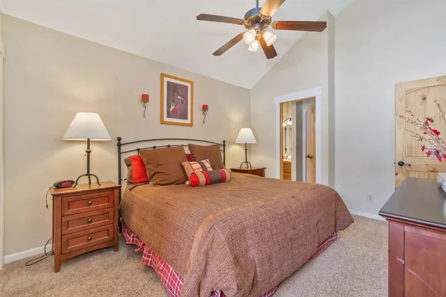 a bedroom with a bed and a lamp on dresser