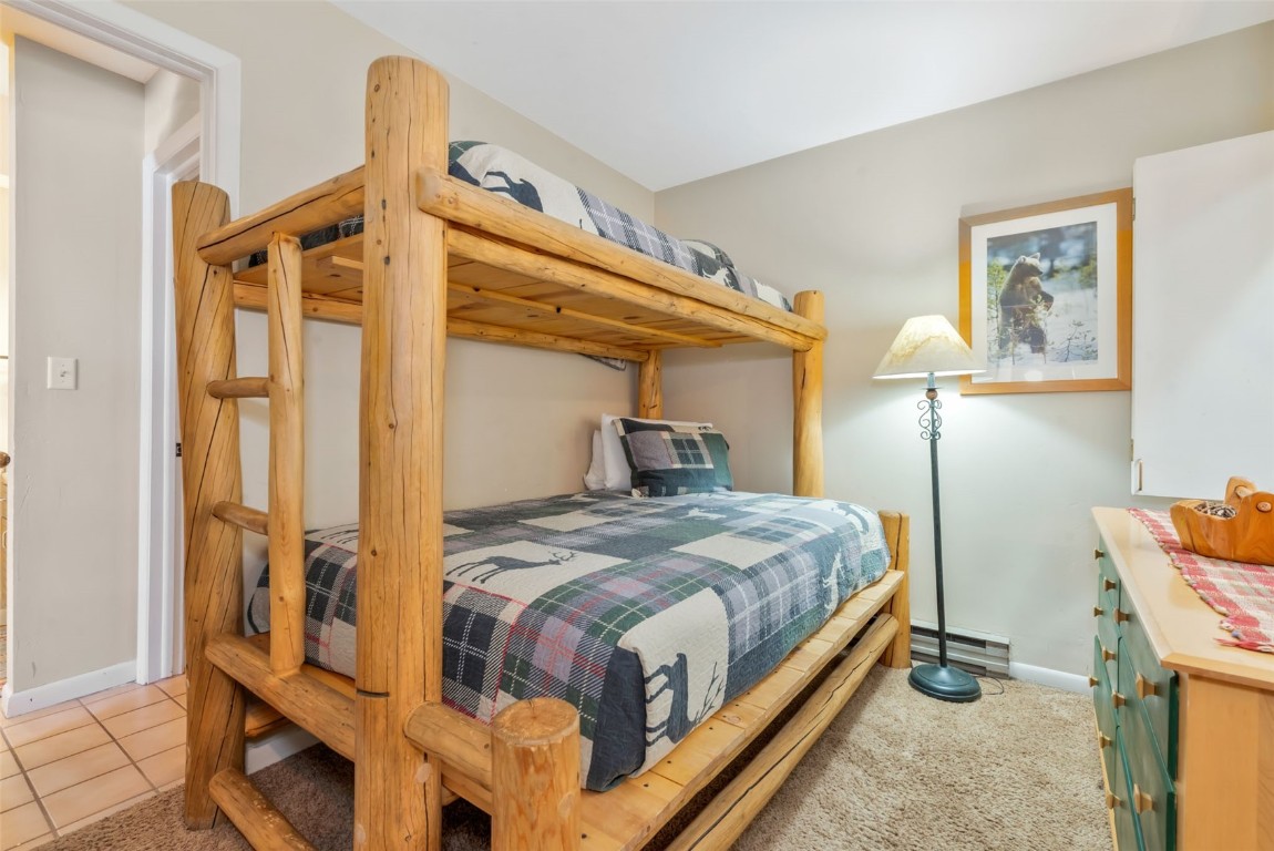 2025 Walton Creek Road, Unit 401 Steamboat Springs, CO 80487 - Photo 29 of 38 a bedroom with a bed and wooden floor
