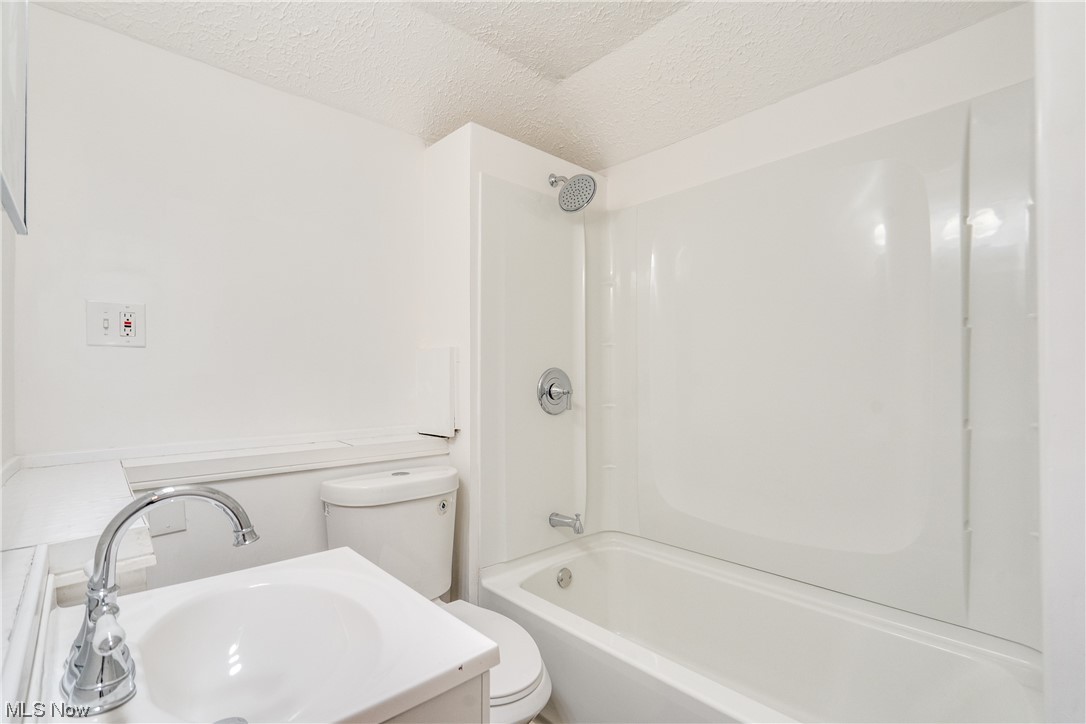 3219 Arbor Road Southwest Canton, OH 44710 - Photo 9 of 15 Full bathroom featuring shower / bathing tub combination, vanity, a textured ceiling, and toilet