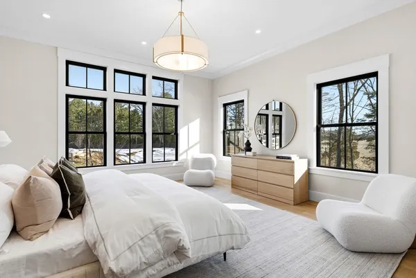 a bedroom with furniture and a large window