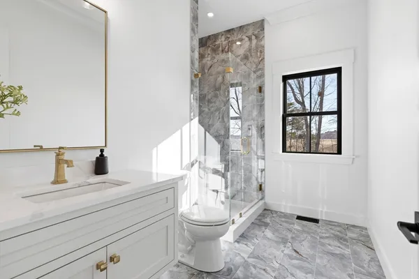 a bathroom with a toilet sink and mirror