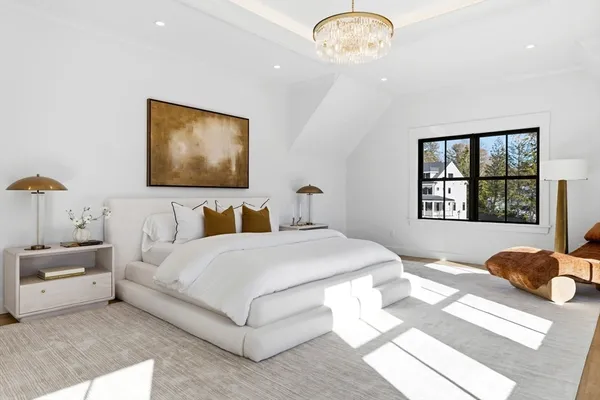 a bedroom with a large bed and a chandelier
