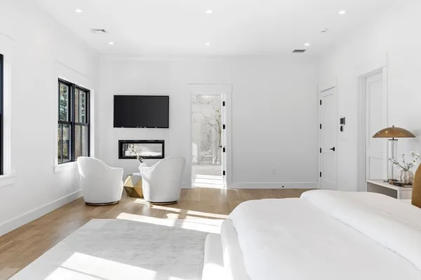a bedroom with a bed a couch and a flat screen tv