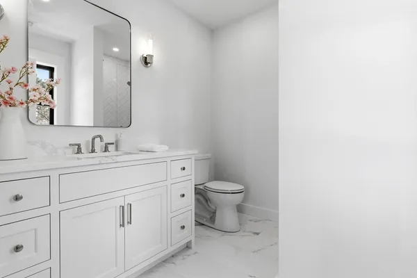 a bathroom with a toilet sink and mirror