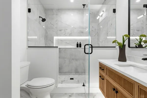 a bathroom with a granite countertop sink a toilet and shower