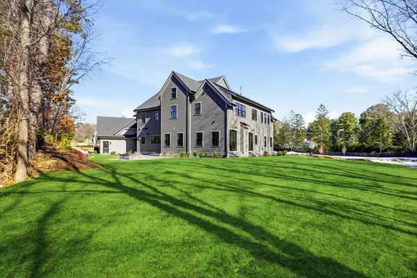 a view of a house with big yard and a large tree