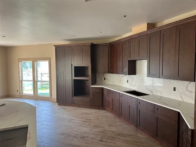a kitchen with a sink cabinets and wooden floor