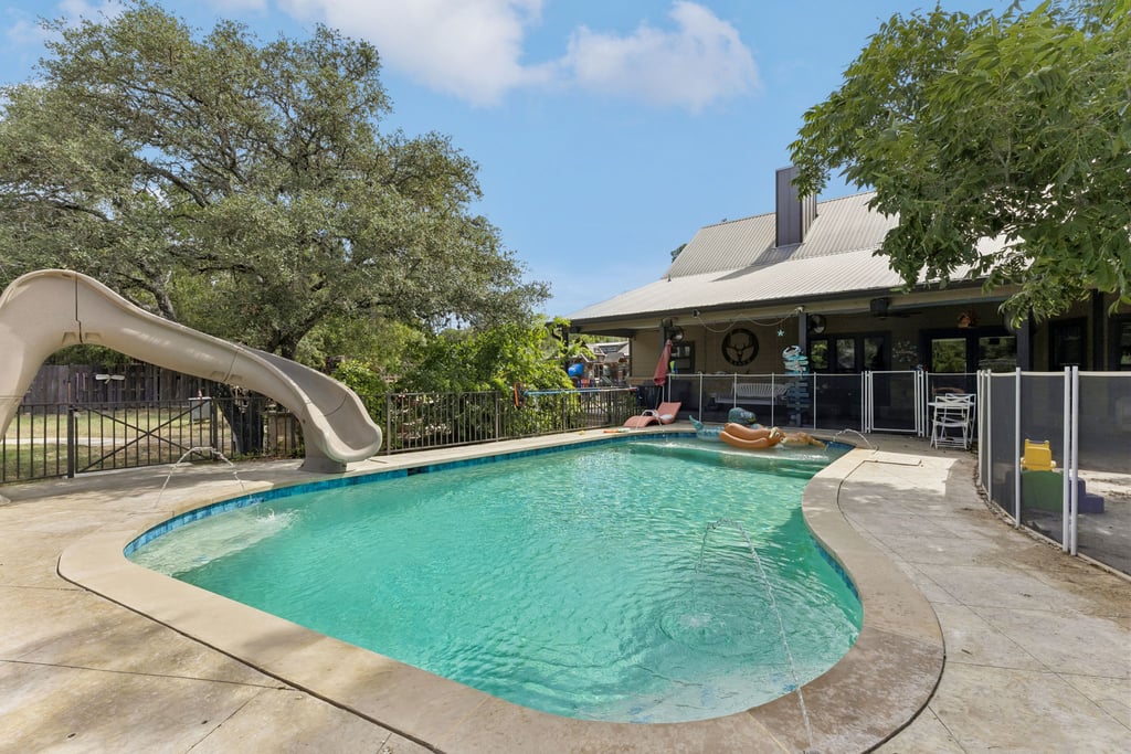 10111 Signal Hill Road Austin, TX 78737 - Photo 24 of 40 A sparkling in-ground pool is surrounded by concrete decking and mature shade trees.