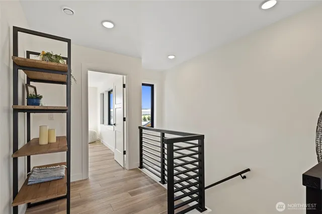 a view of a hallway with wooden floor and furniture