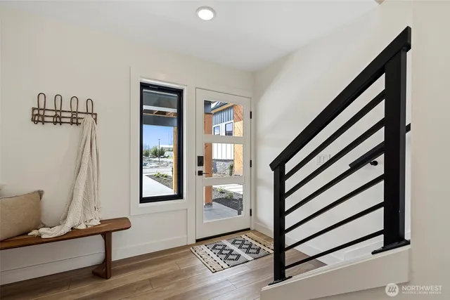 a view of a hallway with wooden floor and staircase