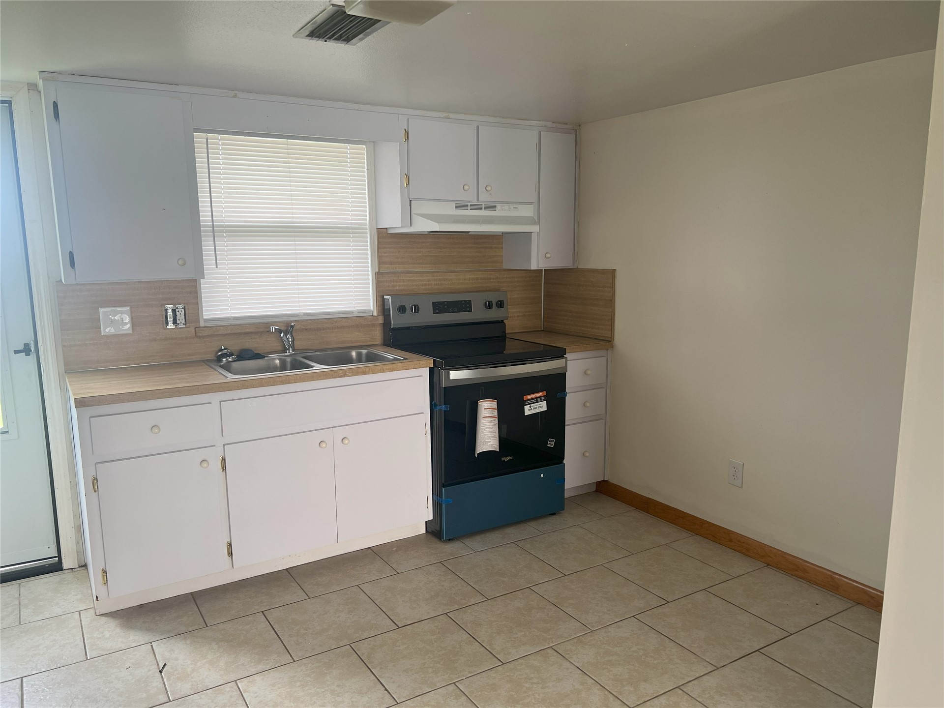 348 Tarpon Avenue Fernandina Beach, FL 32034 - Photo 16 of 44 a kitchen with granite countertop white cabinets and black appliances