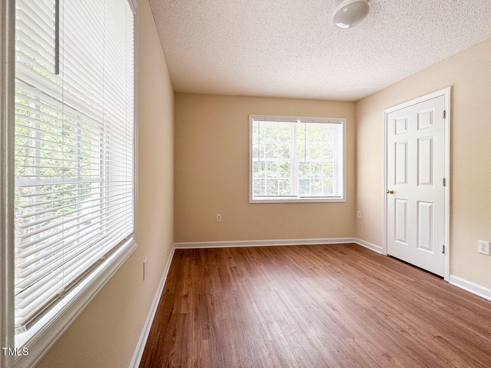 1911 Wolf Tech Lane, Unit 204C Raleigh, NC 27603 - Photo 11 of 18 a view of an empty room with wooden floor and a window