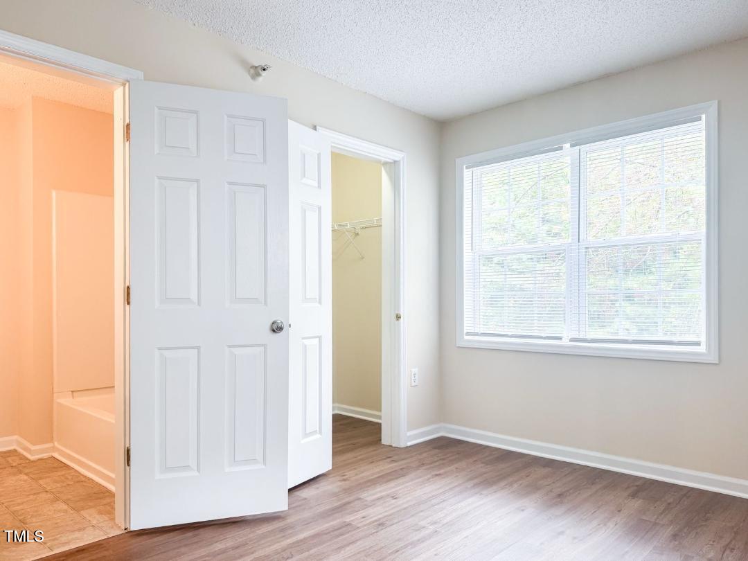 1911 Wolf Tech Lane, Unit 204C Raleigh, NC 27603 - Photo 14 of 18 a view of an empty room with wooden floor and a window