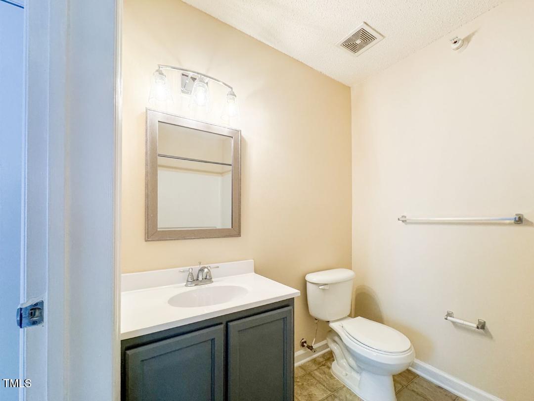 1911 Wolf Tech Lane, Unit 204C Raleigh, NC 27603 - Photo 15 of 18 a bathroom with a toilet a sink and mirror