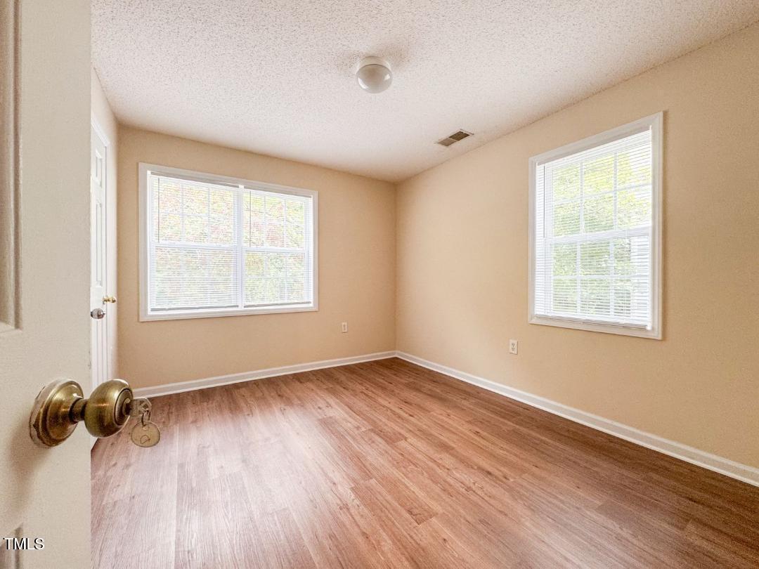 1911 Wolf Tech Lane, Unit 204C Raleigh, NC 27603 - Photo 16 of 18 a view of an empty room with a window and wooden floor