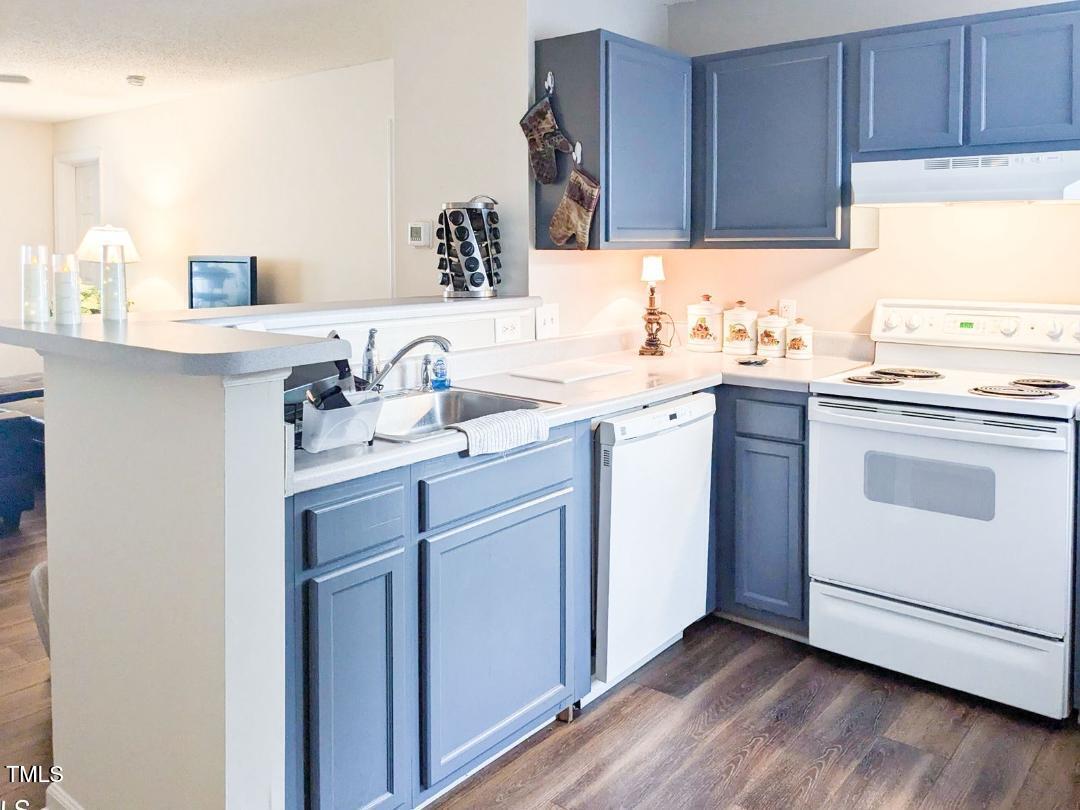 1911 Wolf Tech Lane, Unit 204C Raleigh, NC 27603 - Photo 4 of 18 a kitchen with a sink cabinets wooden floor and a window