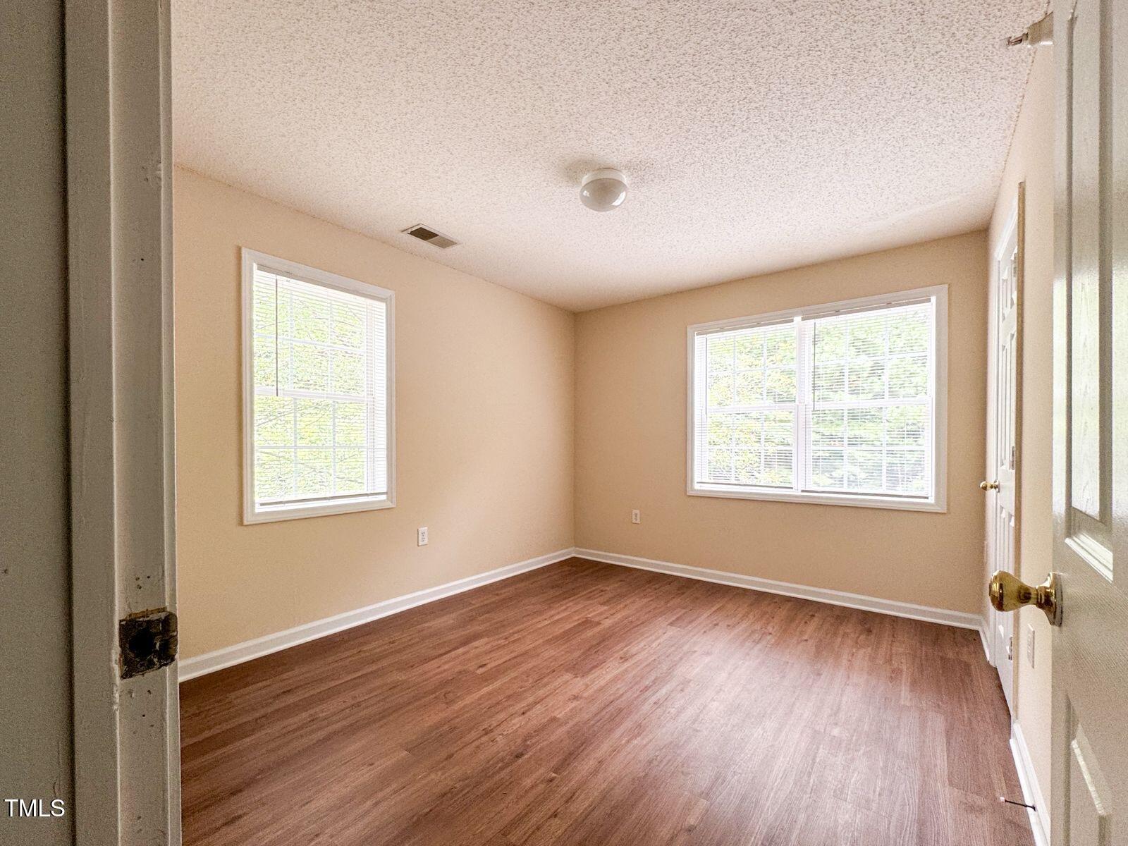 1911 Wolf Tech Lane, Unit 204C Raleigh, NC 27603 - Photo 10 of 18 a view of an empty room with wooden floor and a window