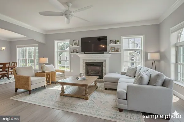 a living room with furniture a flat screen tv and a fireplace