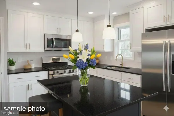 a kitchen with stainless steel appliances granite countertop a sink a stove and a refrigerator