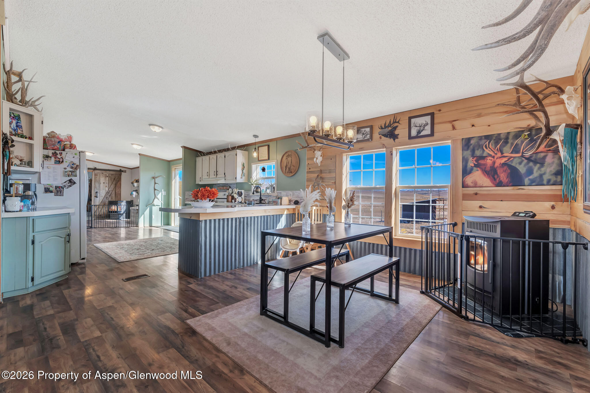 275 Roberts Road Craig, CO 81625 - Photo 11 of 47 a open kitchen with stainless steel appliances granite countertop a stove top oven a dining table and chairs with wooden floor