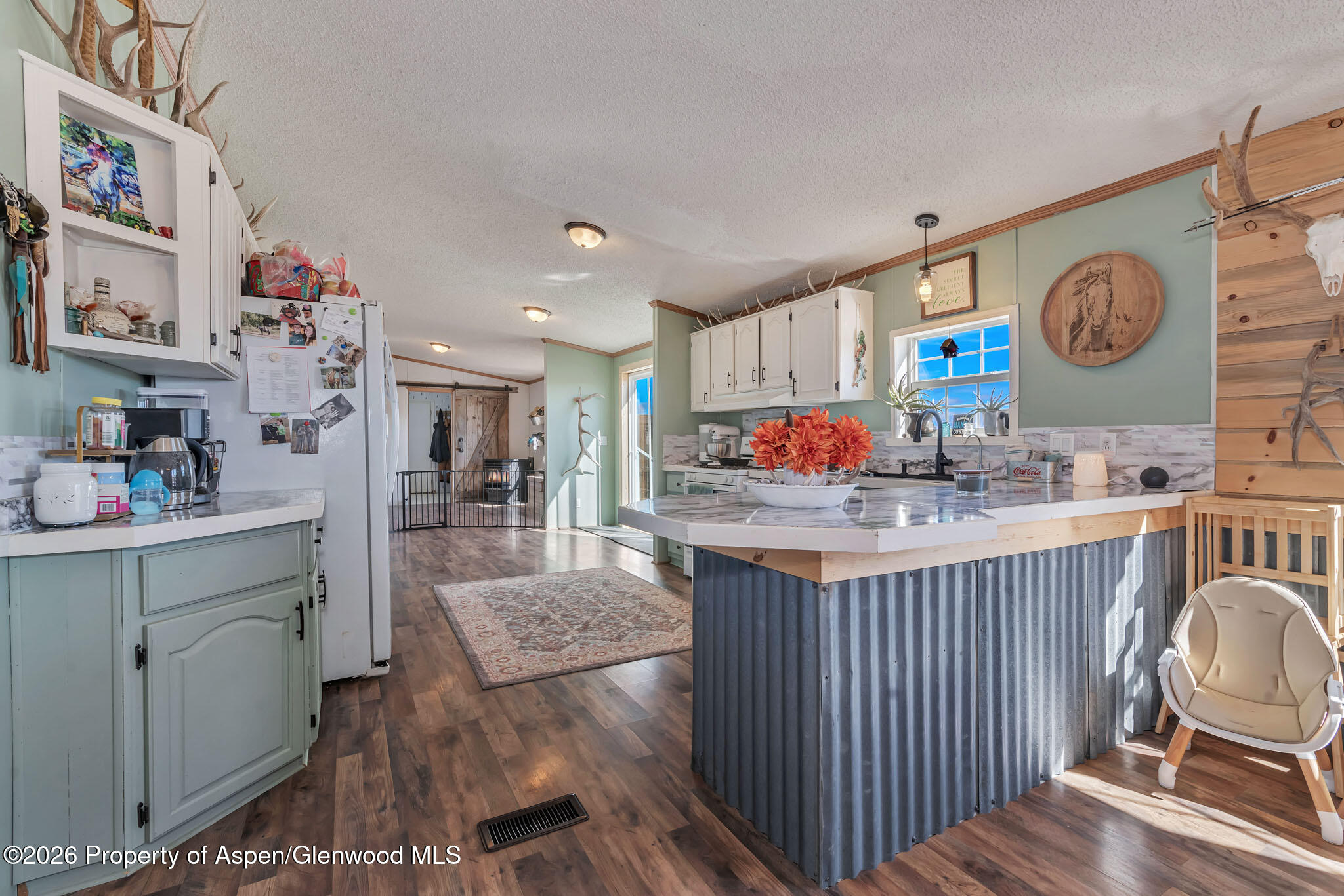 275 Roberts Road Craig, CO 81625 - Photo 12 of 47 a kitchen with stainless steel appliances granite countertop a stove and a dining table with wooden floor