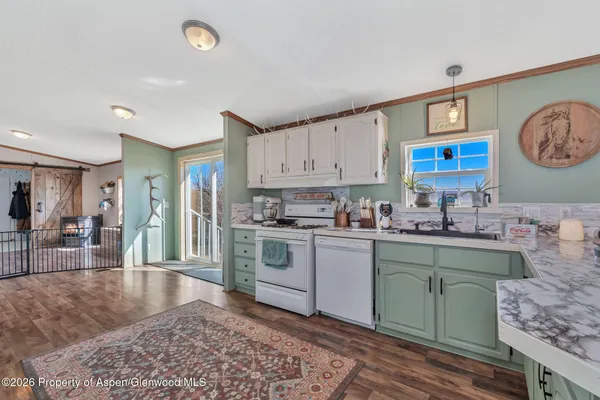 a kitchen with a sink cabinets and wooden floor