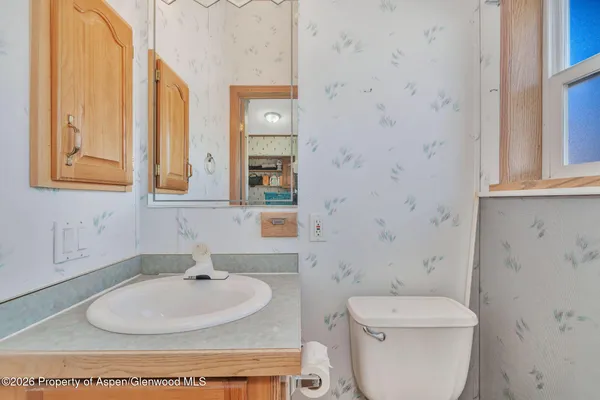 a bathroom with a toilet sink and mirror