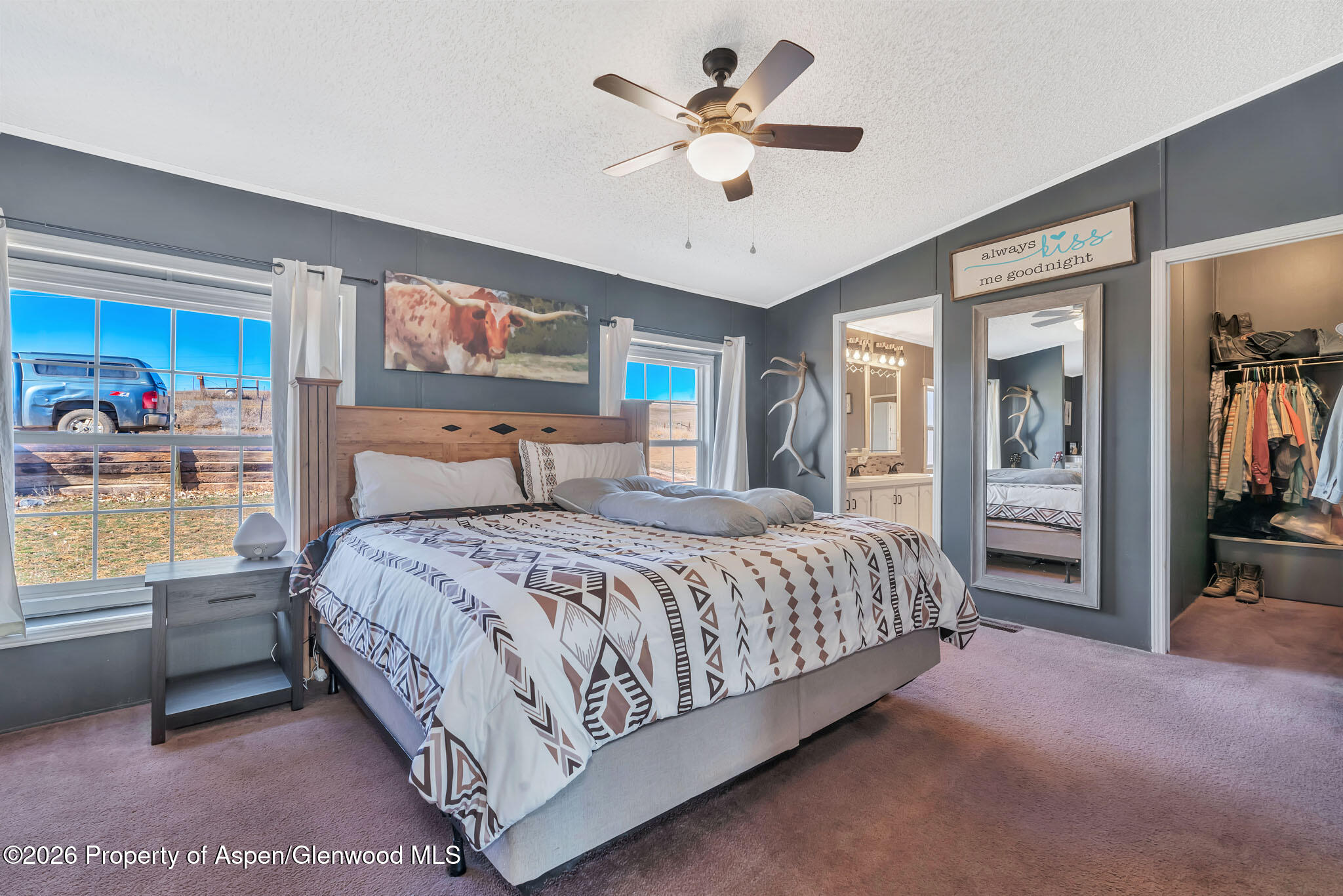 275 Roberts Road Craig, CO 81625 - Photo 20 of 47 a bedroom with a large bed and a chandelier