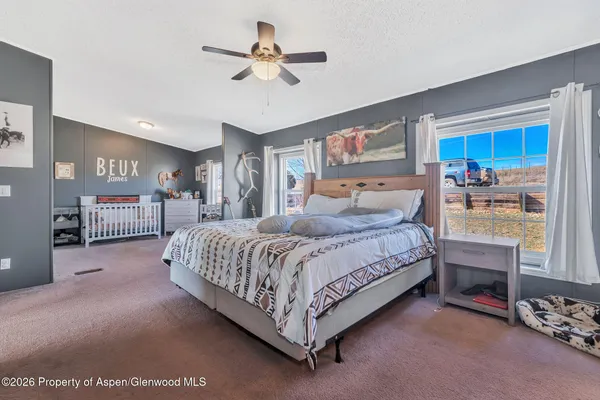 a spacious bedroom with a bed a dresser and potted plant