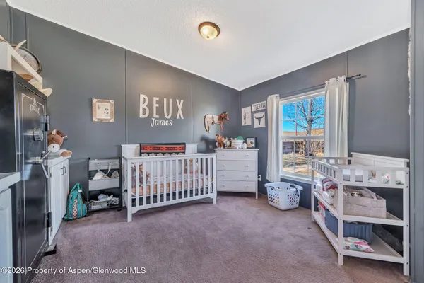 a bedroom with baby crib and a window