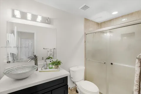 a bathroom with a sink a toilet and shower