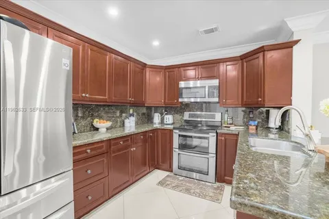 a kitchen with stainless steel appliances granite countertop a refrigerator sink and cabinets