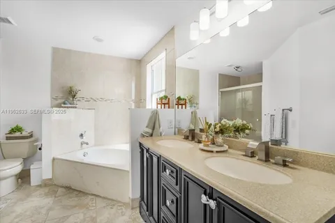 a bathroom with a granite countertop sink a large mirror and a bathtub