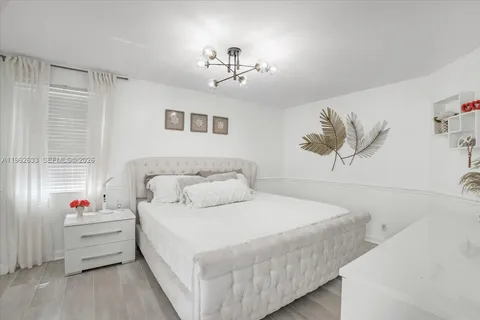 a bedroom with a bed and a chandelier